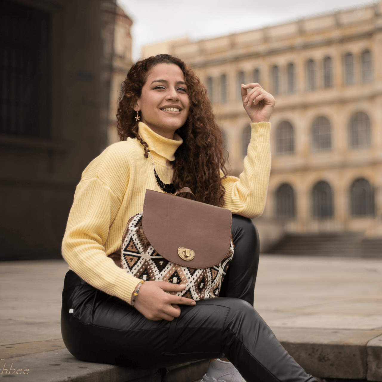 Cienaga backpack showcasing a distinctive Wayuu pattern on the body, accentuated by rich brown genuine leather details. The unique Wayuu designs are presented in an elegant blend of beige, brown, and black shades.