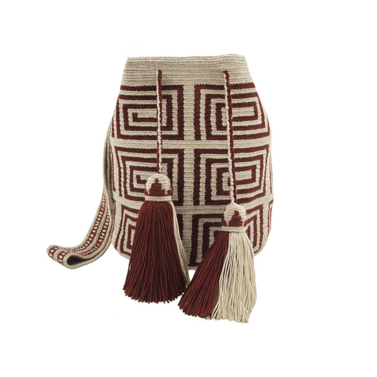 A beige Wayuu Mochila bag with a brown geometric pattern. It has a drawstring closure with tassels.