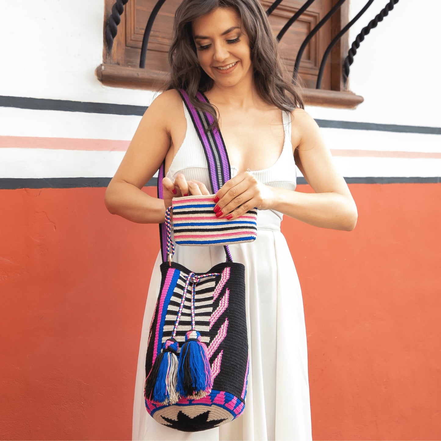 A handmade Wayuu Mochila bag from Colombia, featuring a striking striped design and a separate pouch for small essentials.