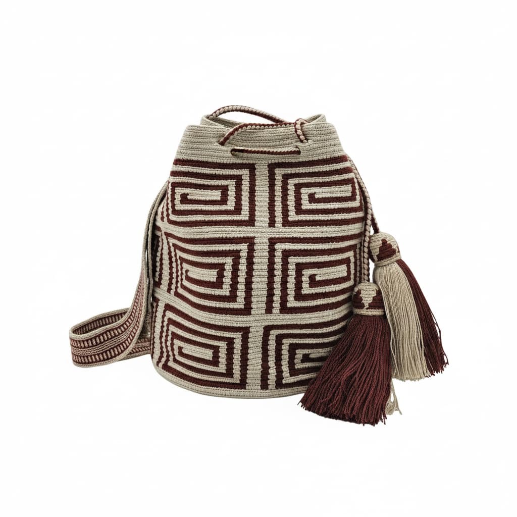 A beige Wayuu Mochila bag with a brown geometric pattern. It has a drawstring closure with tassels.
