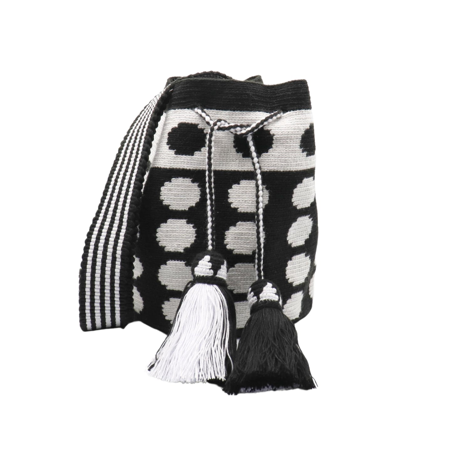 Black and white handmade Wayuu bag with dotted pattern and striped strap.