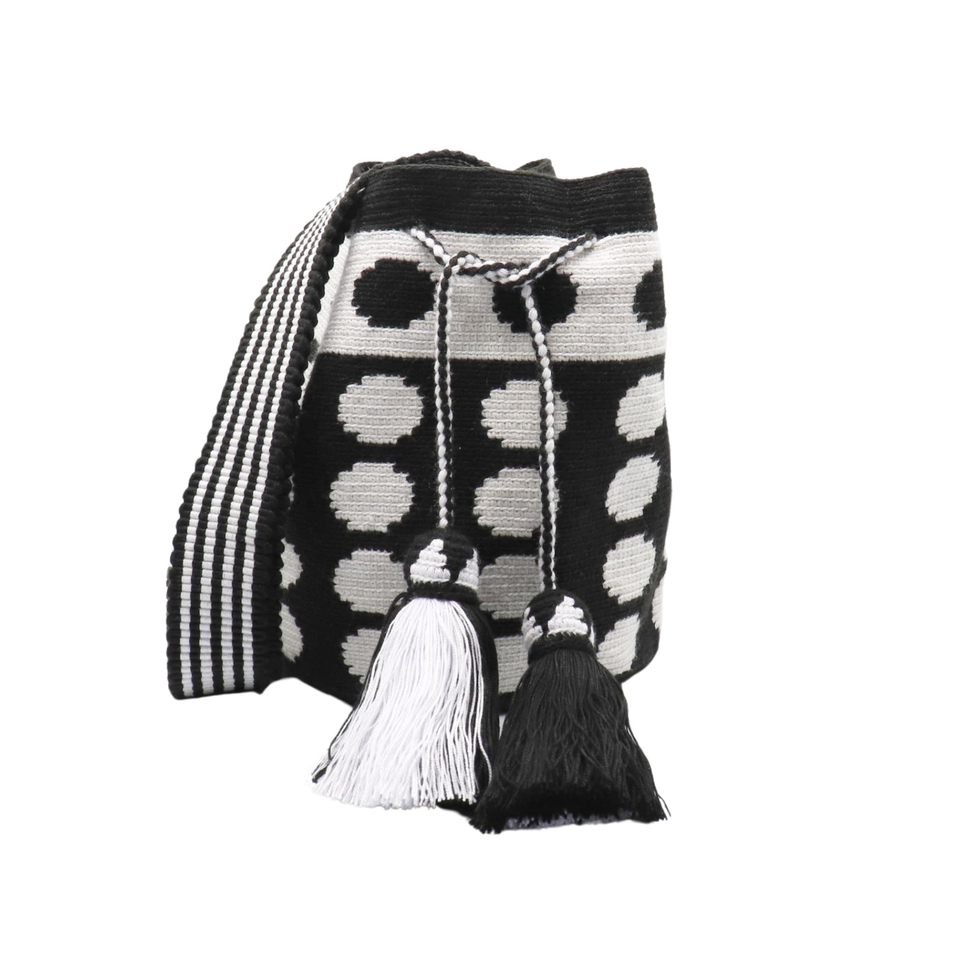 Black and white handmade Wayuu bag with dotted pattern and striped strap.