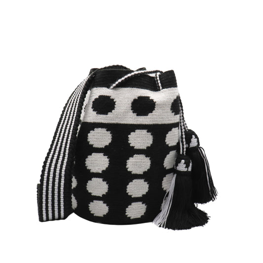 Black and white handmade Wayuu bag with dotted pattern and striped strap.