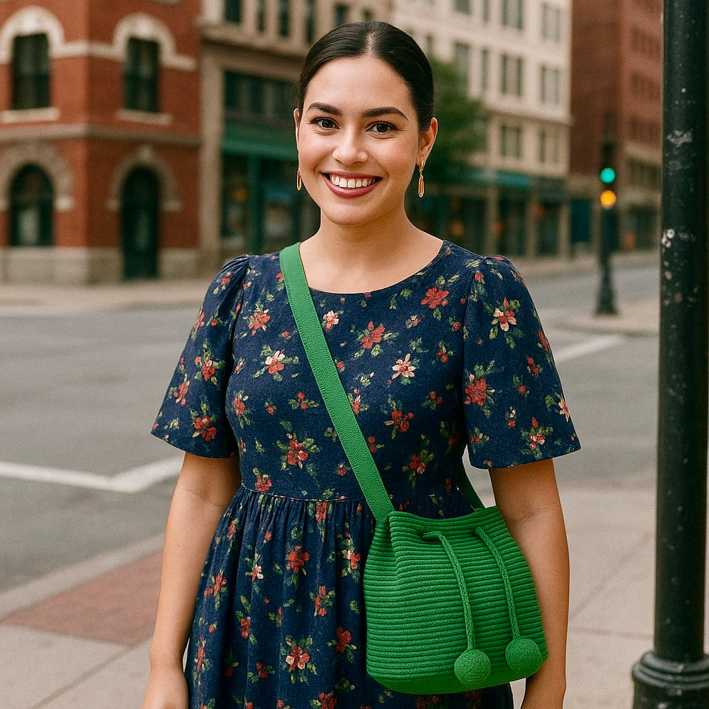 Medium-sized Wayuu bag in solid green color, featuring beautiful pom poms for drawstring closure.