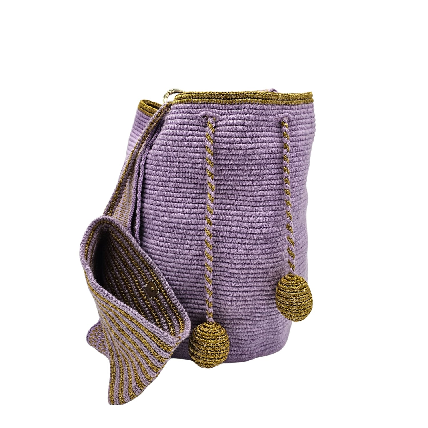 Handcrafted Colombian Wayúu bag in soft lavender with gold braided drawstrings and matching gold pom-poms, featuring a wide shoulder strap with lavender and gold striped detailing.