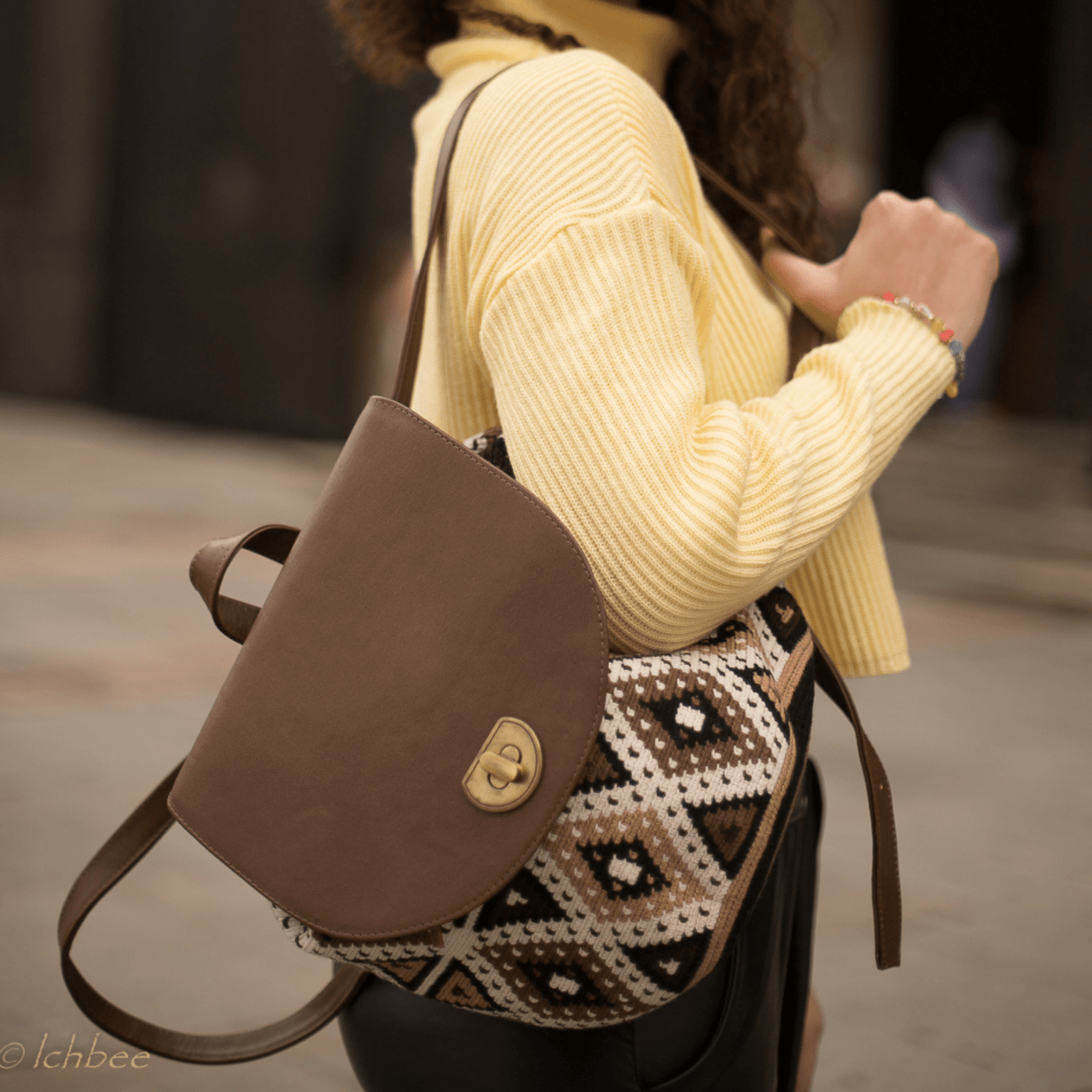 Cienaga backpack showcasing a distinctive Wayuu pattern on the body, accentuated by rich brown genuine leather details. The unique Wayuu designs are presented in an elegant blend of beige, brown, and black shades.