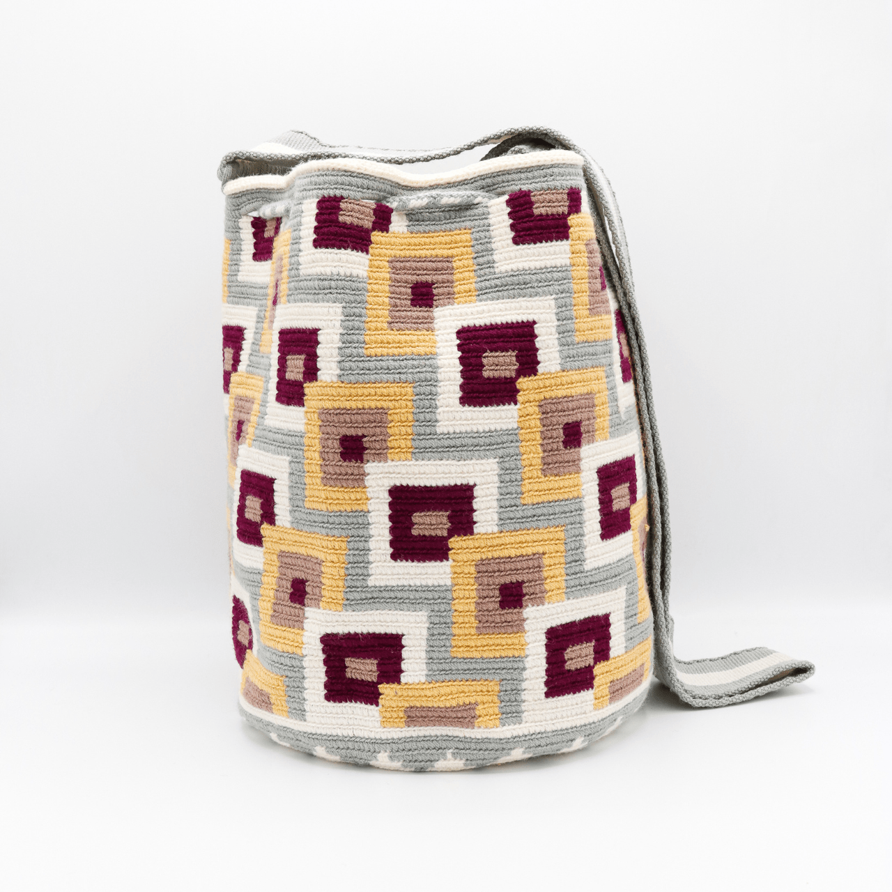 Discover the enchanting Dawn Wayuu Mochila Bag featuring shades of gray, vanilla, burgundy, and dusty pink. This bag boasts a modern design and a truly unique combination of colors, making it a standout accessory.