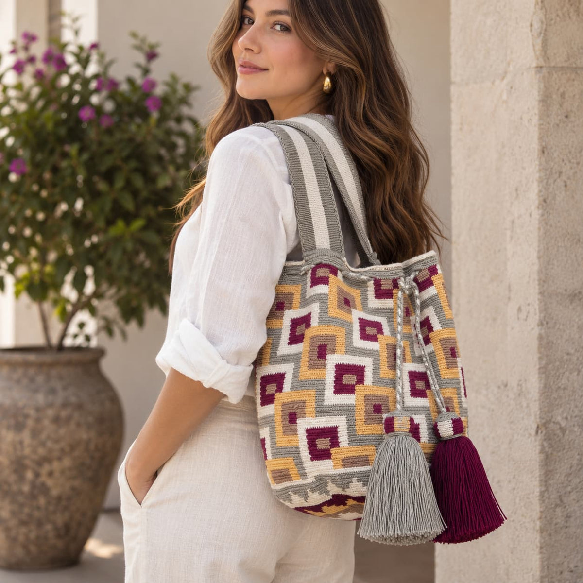 Discover the enchanting Dawn Wayuu Mochila Bag featuring shades of gray, vanilla, burgundy, and dusty pink. This bag boasts a modern design and a truly unique combination of colors, making it a standout accessory.