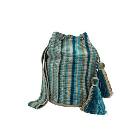 The "Estrella" Wayuu Mochila bag. A striped shoulder bag with shades of blue and beige, a drawstring closure, and tassel details.