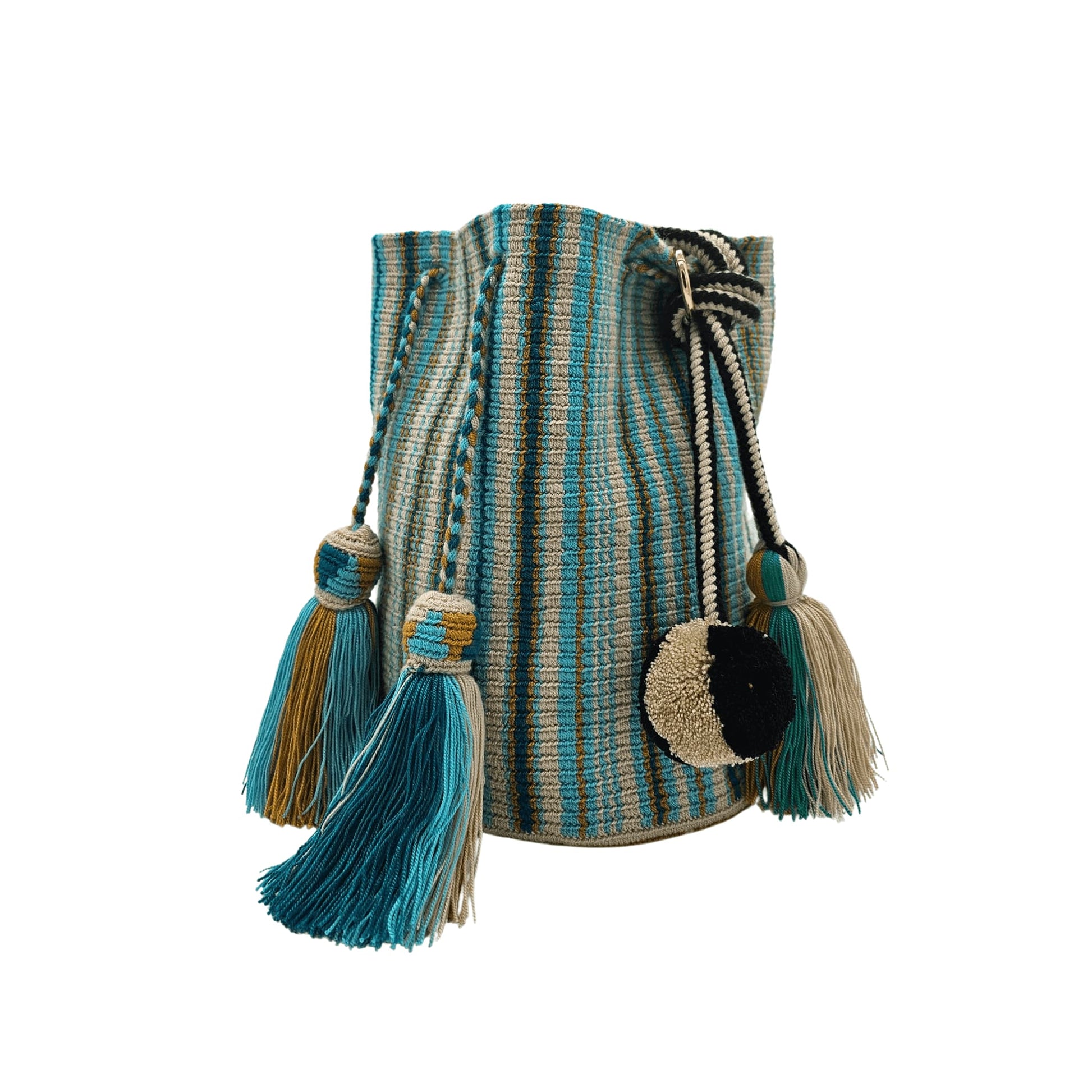 A handcrafted Wayuu bag with a vibrant striped pattern in turquoise, white, and yellow. The bag features a single long, braided black-and-white shoulder strap, a drawstring closure, and decorative tassels with a black pompoms accent.