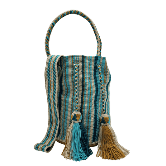 A colorful Wayuu bag with a striped pattern in shades of blue. It has a drawstring closure with tassels and two carrying options: a short handle and a long crossbody strap.