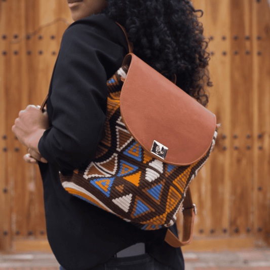 Palomino leather backpack for women, crafted in exquisite tan genuine leather and adorned with a stunning Wayuu design in a harmonious mix of earthy colors and vibrant cobalt blue. A beautiful representation of Wayuu art and the artistic craftsmanship of Colombian artisans.