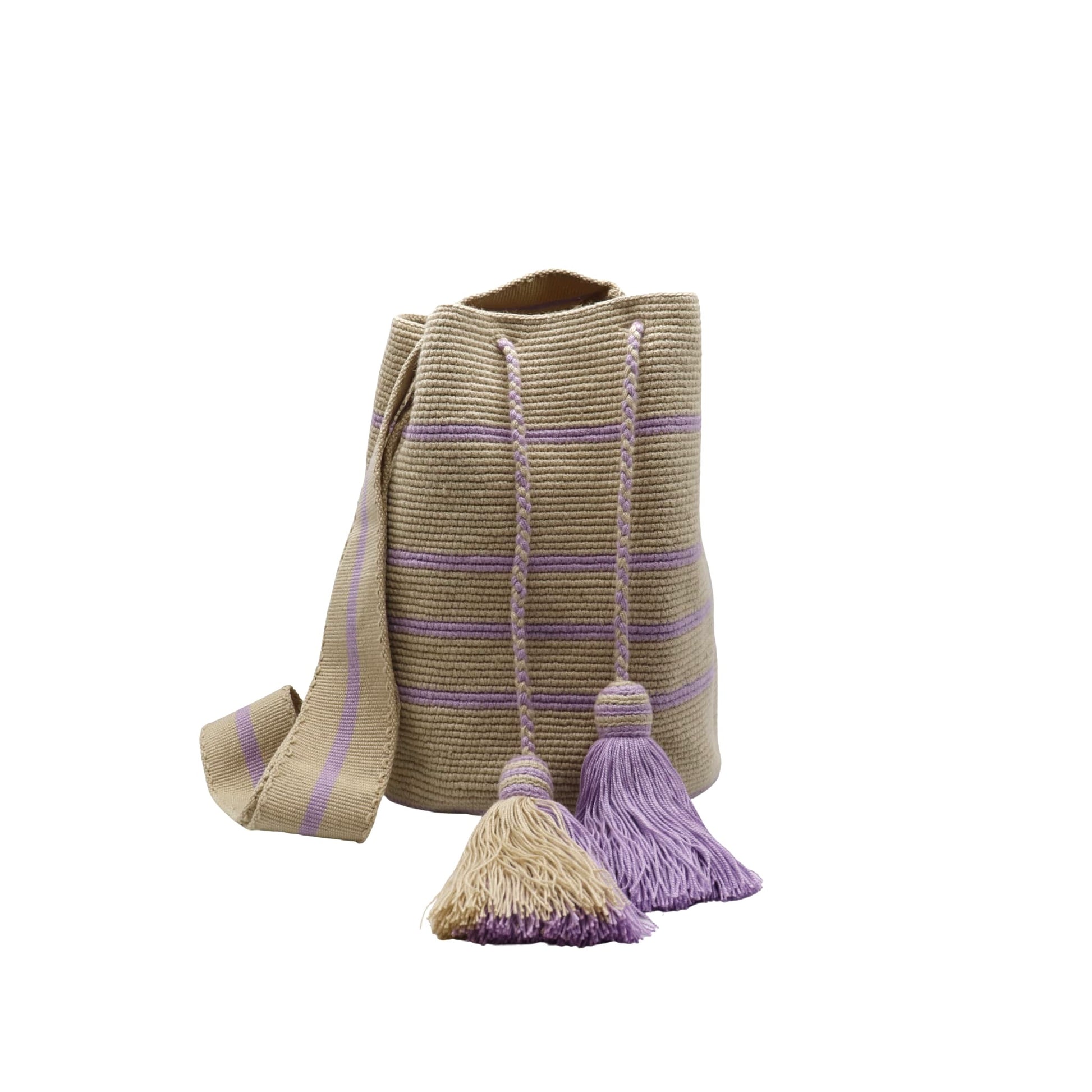 Handwoven Wayuu bag in beige with delicate lavender stripes, featuring a braided shoulder strap and decorative tassels. Ethically crafted by Colombian artisans using traditional crochet techniques.