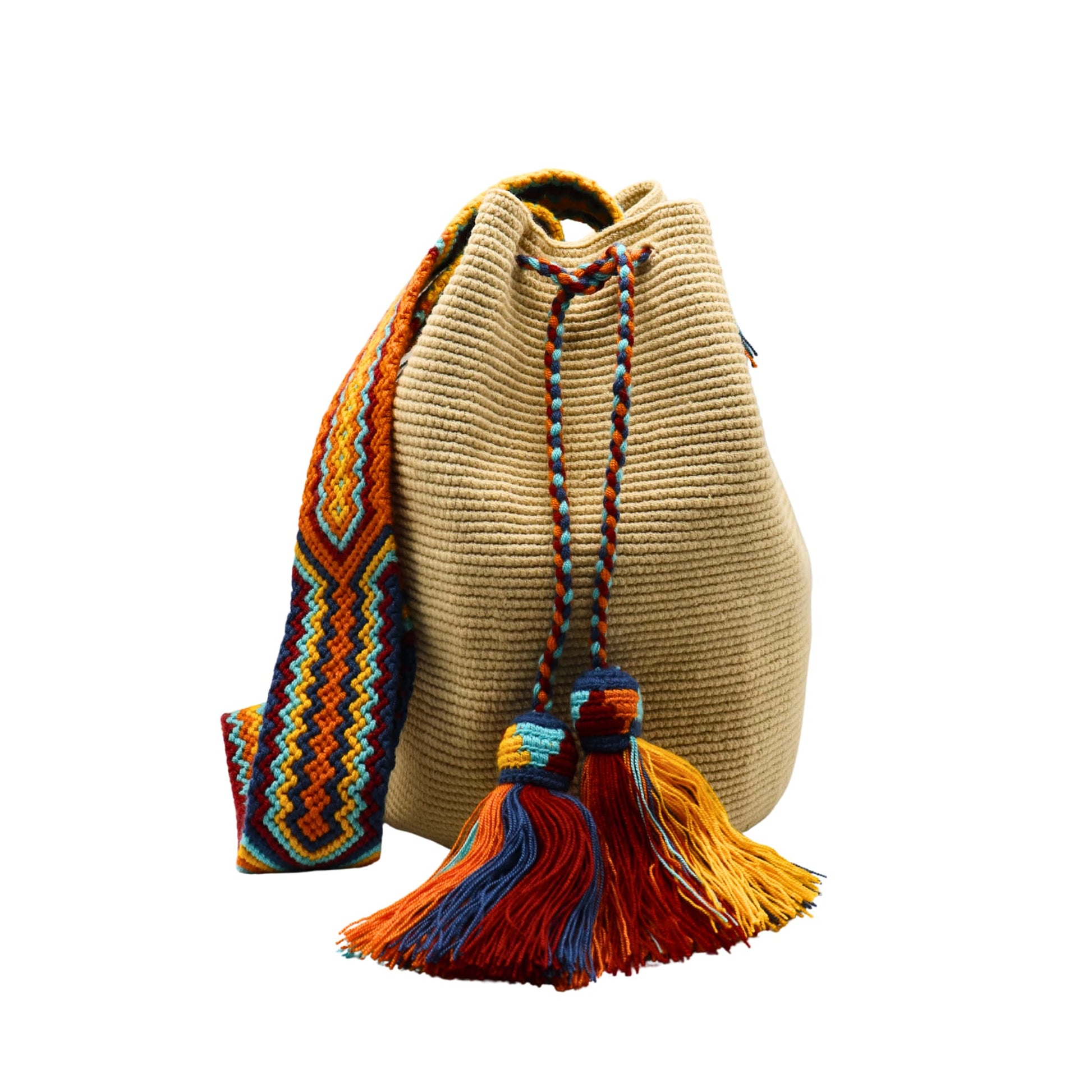Beige handmade Wayuu bucket bag with a wide multicolored macramé strap featuring orange, yellow, aqua blue, navy, and red geometric patterns. The bag has a textured crochet body, braided drawstring closure, and large colorful tassels.